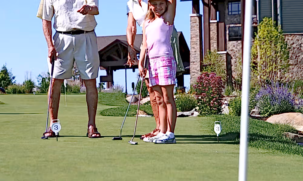 A family playing golf on the putting green at Crystal Springs Resort