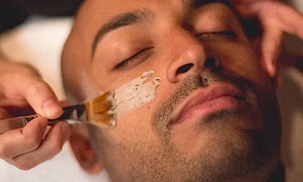 Mask being applied to man's face during facial