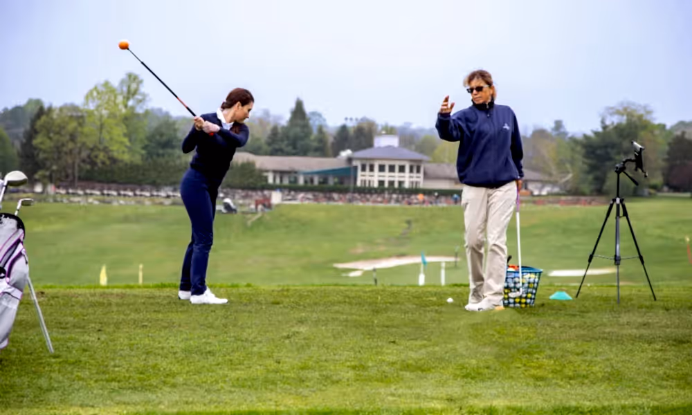 Girl learning to golf by instructor at Leadbetter Golf Academy