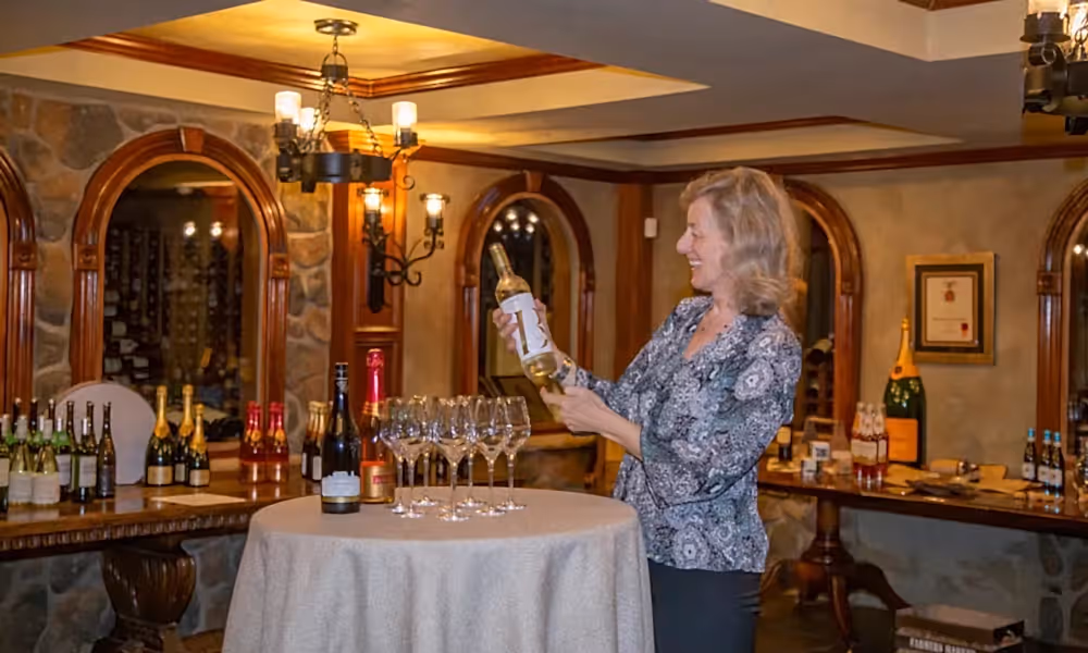 Susanne Wagner holding a bottle of wine in the wine cellar.