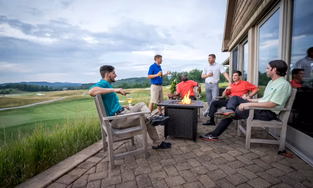 Group of guys enjoying drinks over a fire pit