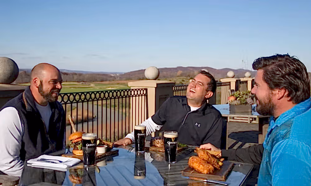 Men laughing and enjoying meals from Owen's Pub at Ballyowen Golf Club