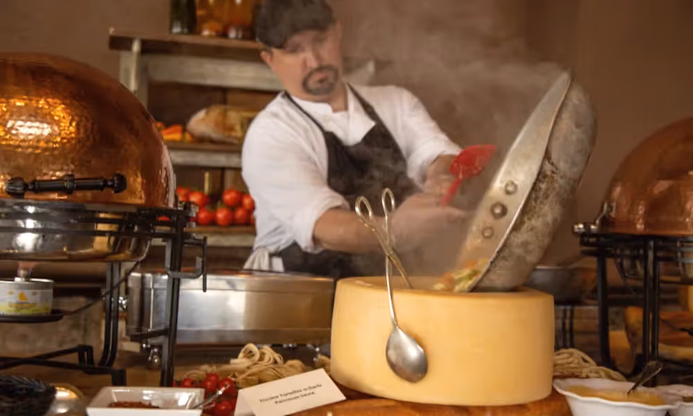 Chef making pasta in a cheese wheel