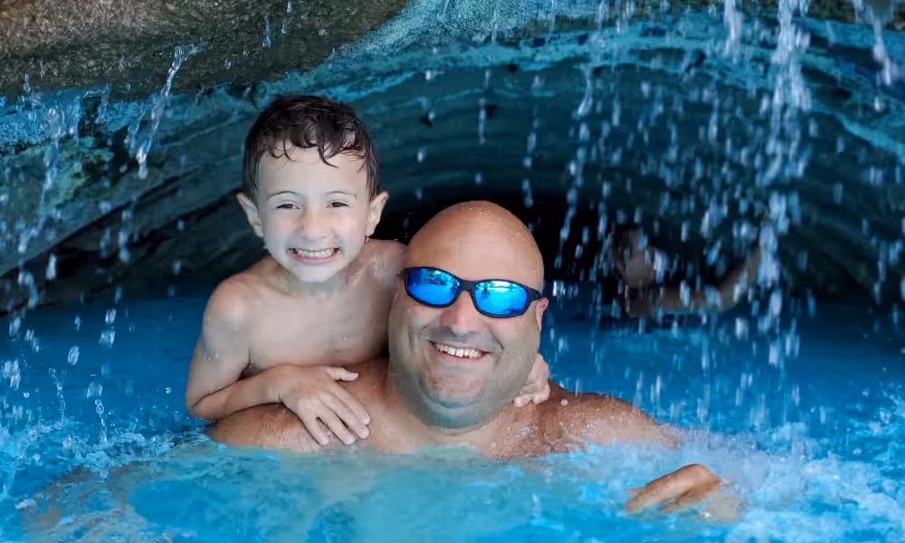 Father and Son under waterfall at minerals pool
