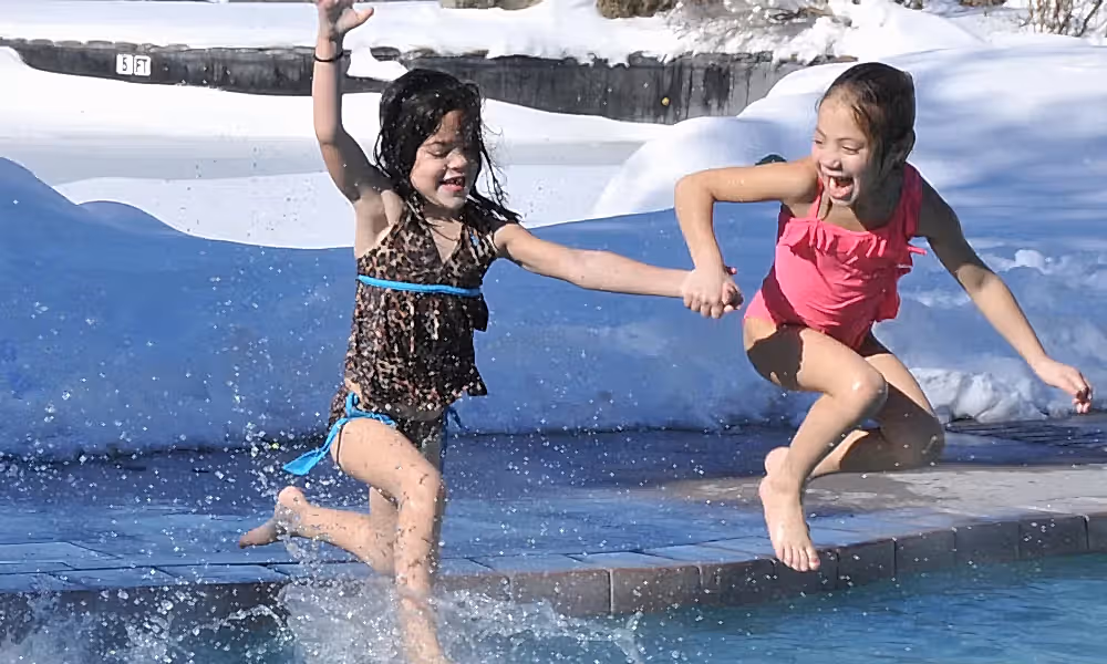 Young girls jumping into the snow pool at Minerals Hotel