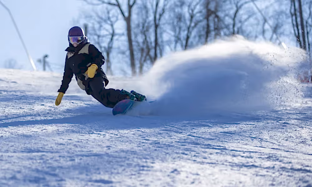 Person snowboarding down mountain.