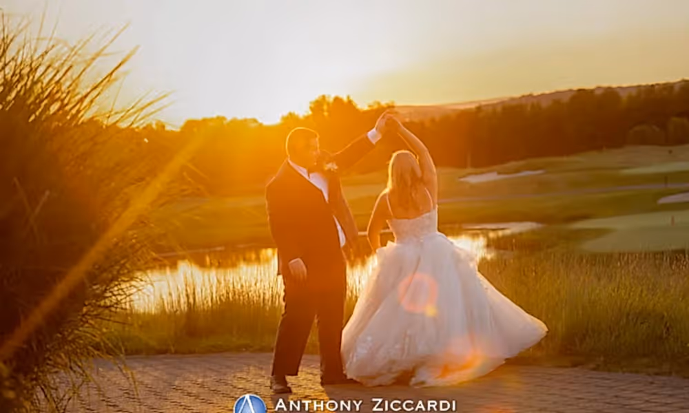 Groom twirling his bride with sunsetting