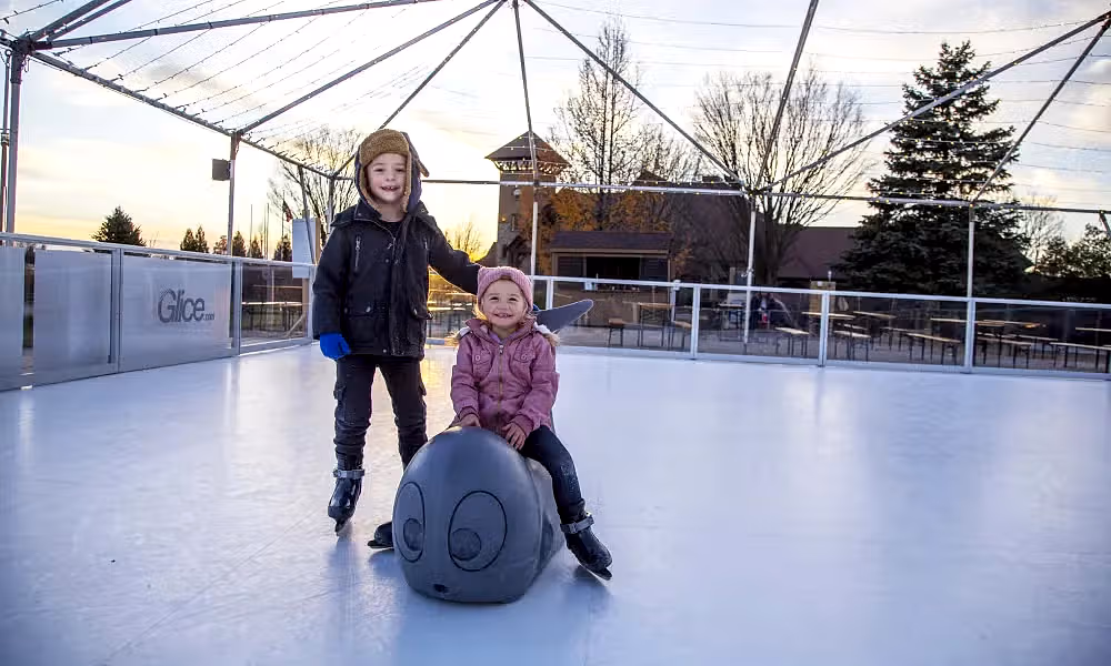Two children glice skating.