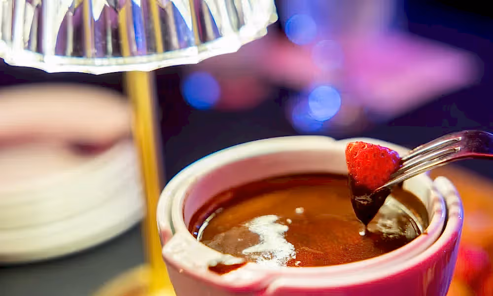 Strawberry being dipped in chocolate at Crystal Cabaret.