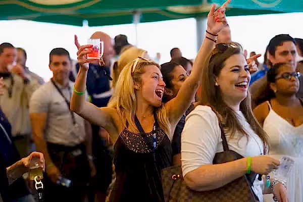 Woman with beer tasting in her hand singing at NJ Beer and Food Festival.