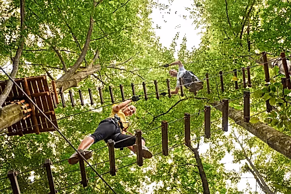 Two people on ropes course ladders.