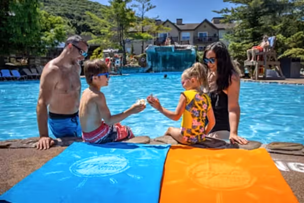 Children enjoying ice cream by the pool with their parents at Minerals Hotel