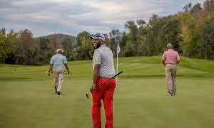 Golfers walking on a golf course.