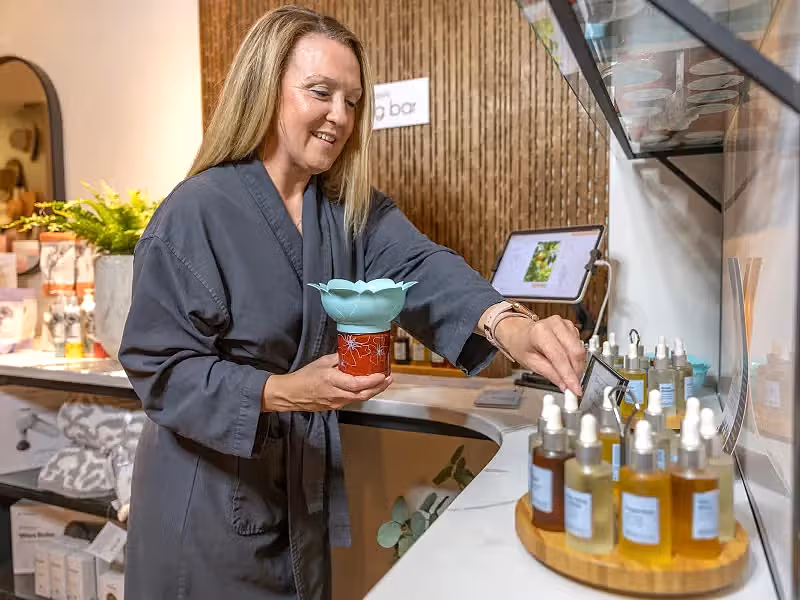 Woman creating a custom blend of oils at the Elements blend bar.